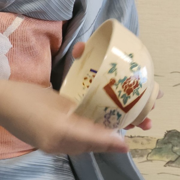 A hand wiping tea cup